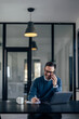 © bnenin - Focused man, working online, making a phone call.