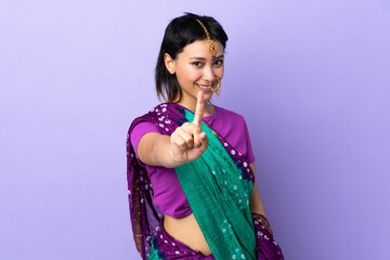 Wall Mural - Indian woman isolated on purple background showing and lifting a finger