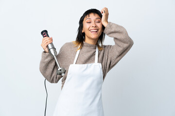 Wall Mural - Chef Uruguayan girl using hand blender over isolated white background laughing