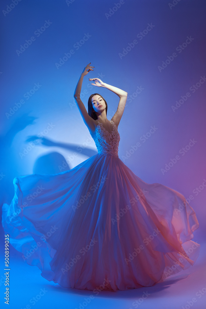 Art fashion beautiful elegant woman in blowing flying dress. Freedom concept in neon color light. Fashion style of flowing dress on body woman Stock Photo | Adobe Stock Art fashion beautiful elegant woman in blowing flying dress. Freedom concept in neon color light. Fashion style of flowing dress on body woman Stock Photo | Adobe Stock