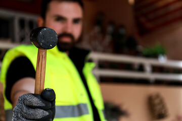 Wall Mural - 
Worker in his work area with a computer, gloves and a mallet hammer