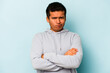 © Asier - Young hispanic man isolated on blue background frowning face in displeasure, keeps arms folded.
