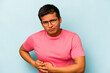 © Asier - Young hispanic man isolated on blue background having a liver pain, stomach ache.