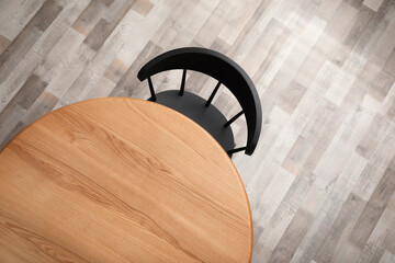 Poster - Round wooden table and black chair indoors, top view