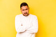 © Asier - Young hispanic man isolated on yellow background suspicious, uncertain, examining you.