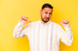 © Asier - Young hispanic man isolated on yellow background feels proud and self confident, example to follow.