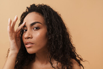 Wall Mural - Shirtless black woman with wavy hair touching her facial skin