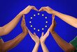 charity, love and valentine's day concept - close up of hands making heart gesture over european union flag on background