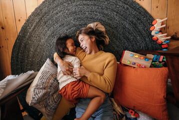 top view of a mother and her daughter laughing cheerfully