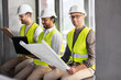 © Syda Productions - architecture, construction business and people concept - group of male architects in helmets with laptop, blueprint and clipboard working at office