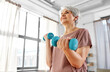 © Syda Productions - sport, fitness and healthy lifestyle concept - smiling senior woman with dumbbells exercising at home