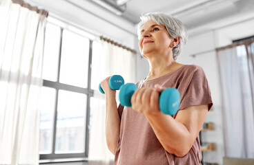 Canvas Print - sport, fitness and healthy lifestyle concept - smiling senior woman with dumbbells exercising at home