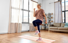 Sport, Fitness And Healthy Lifestyle Concept - Smiling Senior Woman Exercising On Mat And Walking On Spot At Home