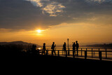 Fototapeta Most - silhouette of a tourist looking at the sunset at the river