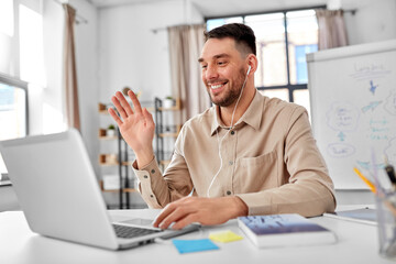 Sticker - distant education, school and remote job concept - happy smiling male teacher with laptop computer having online class or video call at home office