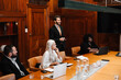© Maskot - Smiling businessman in conference meeting with colleagues at board room
