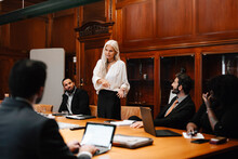 Confident Businesswoman Discussing With Lawyers In Board Room During Conference Meeting