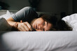 © Maskot - Tired woman suffering from mental health disorder lying on bed alone at home