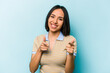 © Asier - Young hispanic woman isolated on blue background pointing to front with fingers.