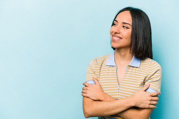 Wall Mural - Young hispanic woman isolated on blue background smiling confident with crossed arms.