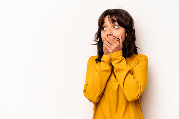 Wall Mural - Young hispanic woman isolated on white background thoughtful looking to a copy space covering mouth with hand.