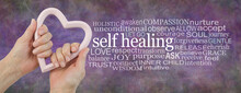 Heart-felt Self-healing Word Cloud Background Banner -  Female Hands Holding A Pink Heart Shaped Frame Beside A Self Healing Word Cloud On A Rustic Multicoloured Background

