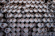 Close up full frame view of rows of stacked oil and gas industry iron metal drilling pipes	