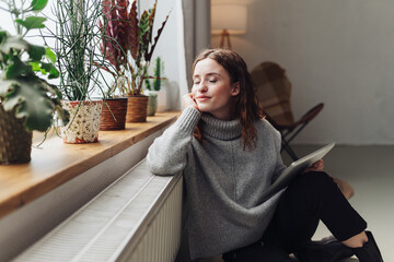 young woman relaxed at heater with tablet in hand