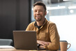 © Prostock-studio - Cheerful Male Entrepreneur Posing Near Laptop Working In Modern Office