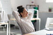 © Prostock-studio - Calm female company employee leaning on chair with hands behind head, relaxing after completed job at workplace