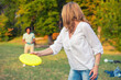 Young couple throwing frisbee in the nature on a sunny summer day