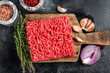 Raw Mince, minced Ground beef meat on a cutting board. Black background. Top view