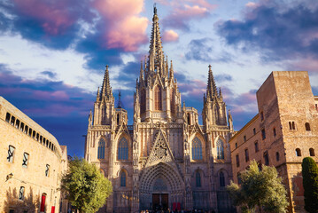 Wall Mural - Gothic cathedral in Barcelona, Catalonia, Spain. Entrance in Barcelona Cathedral with tower. Ancient architecture of old town with medieval houses. Blue evening sky with clouds and antique street.