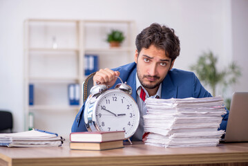 Wall Mural - Young male employee in time management concept