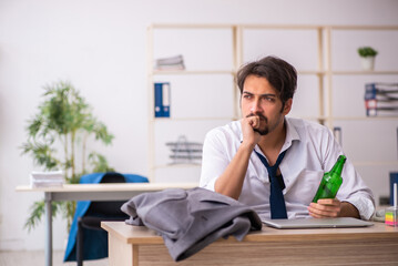 Poster - Young alcohol addicted employee sitting in the office