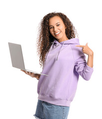 Wall Mural - Beautiful young African-American woman in stylish hoodie and with laptop on white background