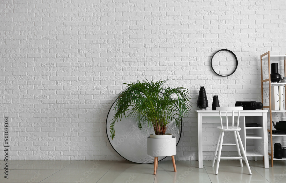 Interior of modern photo studio with workplace and different equipment