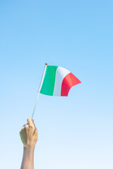 Wall Mural - hand holding Italy flag on nature background. National Day, Republic Day, Festa della Repubblica and happy celebration concepts