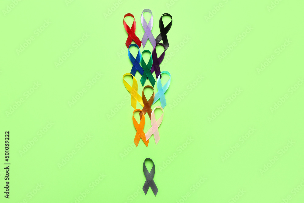 Awareness ribbons on green background. World Cancer Day concept