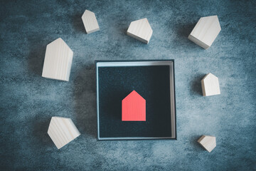 Poster - Wooden houses with a single red wooden house in black box