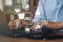 Businessman Using A Computer To "UGC" Abbreviation And Icon On Laptop Computer. User-generated Content Concept.(UGC) Online Marketing Concept. Customer Create Content On Social Media.