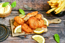   Allasca Pollock Fish  Bites In A Crispy Tempura  Batter.Fish And Chips .Close Up Of   Crispy Breaded  Deep Fried Fish Fingers With Breadcrumbs S Erved With Remoulade Sauce And  Lemon
