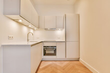 A Spacious Room With Parquet Floors And A Corner Kitchen In A Minimalist Style In A Modern House