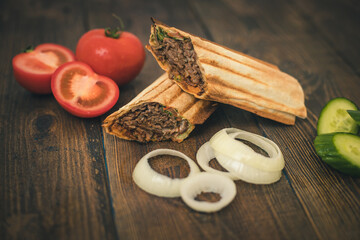 Wall Mural - doner or shawarma in lavash on a wooden background