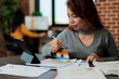 © DC Studio - Portrait of asian businesswoman analyzing management graphs on tablet computer working at business strategy in startup office. Executive manager standing at table planning partnership