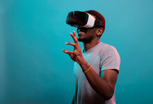 Young Man Having Fun With Interactive Virtual Reality Headset, Using Modern Technology With Futuristic 3d Vision. Millennial Adult Wearing Gaming Glasses With Visual Simulation For Leisure.