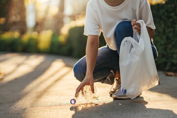 Volunteer woman collects trash in the trash bag. Plastic pollution and environmental problem concept. Greening the world, Trash-free planet concept.