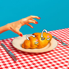 Female hand tasting crispy croissant on plaid tablecloth isolated on bright blue background. Vintage, retro style interior. Food pop art photography.