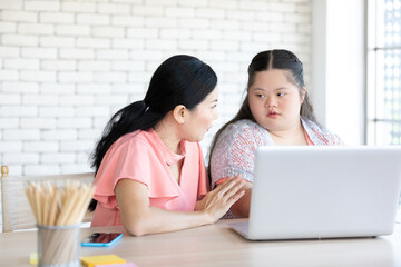 Wall Mural - down syndrome teenage girl and her teacher using laptop computer together on a table