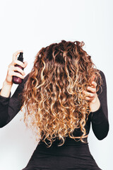 Wall Mural - Head of young woman with long curly hair